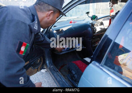 Herat, Afghanistan. 24 Feb, 2019. Ein afghanischer Polizist sucht ein Fahrzeug an ein Security Checkpoint entlang Herat-Farah Hauptstraße in Herat, Afghanistan, 24.02.2019. Die afghanischen Sicherheitskräfte neun Taliban Kämpfer getötet haben und beschlagnahmt fast 900 kg Suchtstoffen während separate Arbeitsgänge, das Afghanische Ministerium für Inneres sagte Samstag. In der Provinz Herat, der afghanischen nationalen Polizei (ANP) ergriff mehr als 570 kg von Betäubungsmitteln und Opium und ein Fahrzeug nach dem ANP legte einen Hinterhalt und engagierte sich mit Drogenhändlern an einer Hauptstraße. Credit: Elaha Sahel/Xinhua/Alamy leben Nachrichten Stockfoto