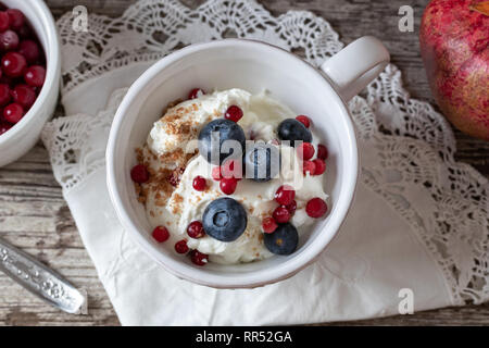 Quark mit Leinsamen, Blaubeeren, Preiselbeeren und Johannisbeeren eingefroren Stockfoto