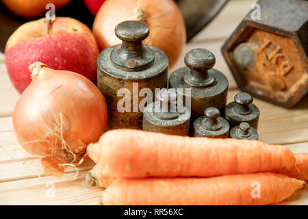 Alten rostigen Gewicht der Waage auf Holztisch, alte rostige Bügeleisen Gewicht der Waage, Gemüse Stockfoto