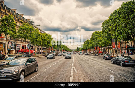 Paris, Frankreich - Juni 02, 2017: Avenue des Champs Elysees mit viel Verkehr. Elysian Fields Road an bewölkten Himmel. Urlaub und Reisen in die französische Hauptstadt. Stockfoto