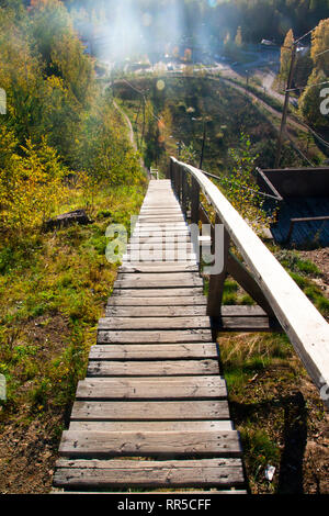 Lange Holz Treppe nach unten von der Oberseite der Bush-Hügel bedeckt. Stockfoto