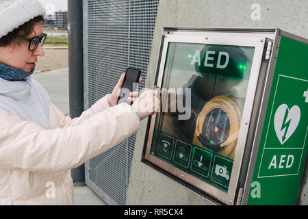 Medizin kardiopulmonale Reanimation Notruf. Kaukasische Frau nutzt Telefonieren 911 helfen. Gerät aed automatischer Defibrillator Krankheit Stockfoto