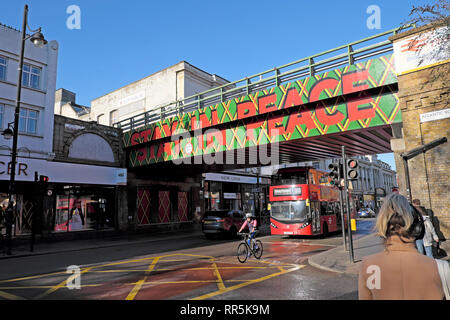 Aufenthalt in Frieden Zeichen auf Eisenbahnbrücke über Brixton Road und Menschen, Verkehr in der Straße in Brixton, London SW9 England UK KATHY DEWITT Stockfoto