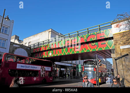 Aufenthalt in Frieden Zeichen auf Eisenbahnbrücke über Brixton Road und Menschen, Verkehr in der Straße in Brixton, London SW9 England UK KATHY DEWITT Stockfoto