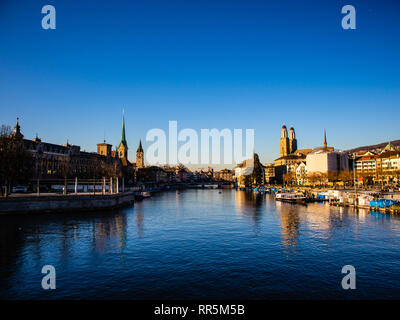 Blick auf die Altstadt der Stadt Zürich mit berühmten Fraumunster und Grossmünster Kirchen und Limmat am Zürichsee auf einem Sonnenuntergang im Winter, Schweiz Stockfoto