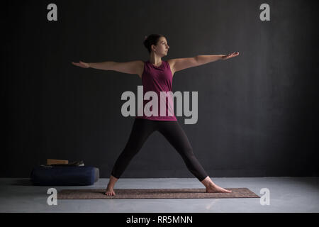 Attraktive junge Frau, die innen Yoga Übung Stockfoto