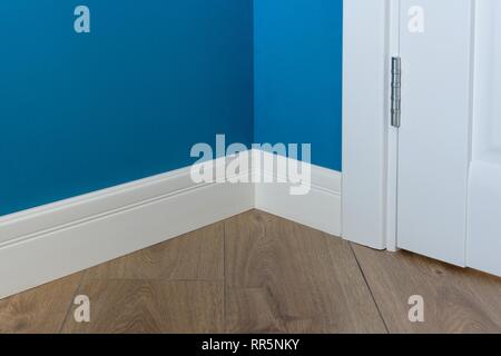 Formen in der Ecke. Blau Matt Wand mit laminiertem Parkett Eiche immitating Textur Stockfoto