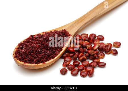 Boden Sumac in Löffel aus Holz und sumach Beeren auf weißem Hintergrund Stockfoto