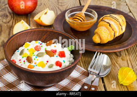 Frische Hüttenkäse mit kandierten Früchte und Nüsse, Honig, Croissants zum Mittagessen. Studio Foto Stockfoto