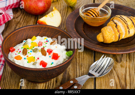 Frische Hüttenkäse mit kandierten Früchte und Nüsse, Honig, Croissants zum Mittagessen. Studio Foto Stockfoto