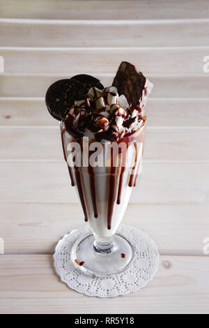 Milchshake mit Kuchen, Eibisch und Karamell Sirup nach unten fließt das Glas. Unordentliche Trend in Food Styling. Stockfoto