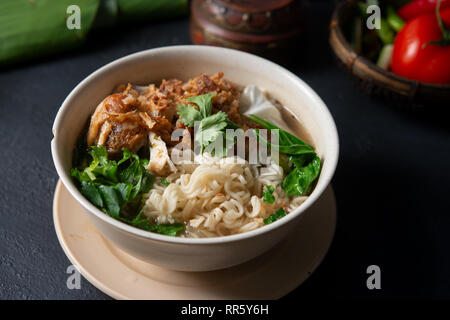 Asiatische Ramen Nudeln Suppe und Hühnchen in der Schüssel auf dunklem Hintergrund. Stockfoto