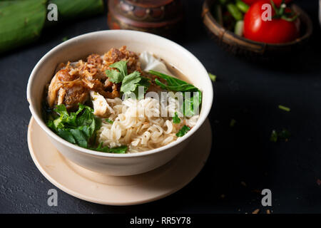 Asiatische Ramen Nudeln Suppe und Hühnchen in der Schüssel auf dunklem Hintergrund. Stockfoto