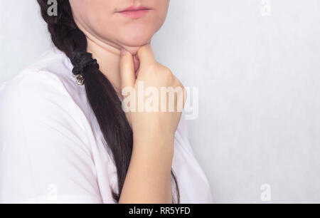 Das Mädchen hält ihre Hand hinter dem Doppelkinn auf einem weißen Hintergrund, Kopieren sapce, Porträt Stockfoto