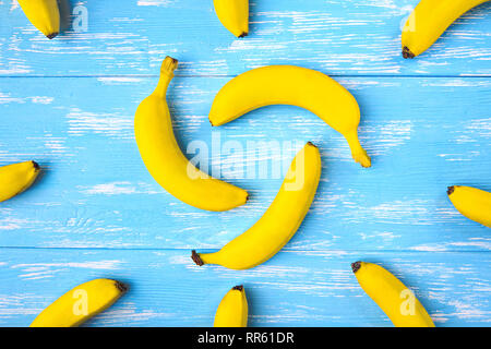 Bananen auf blauem Holz- Tabelle, Ansicht von oben. Stockfoto
