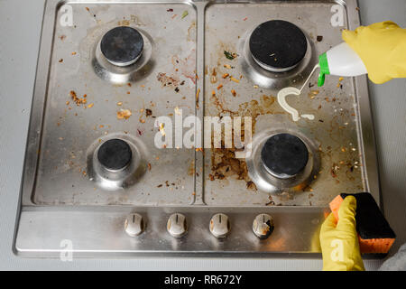 Anwendung von Reinigungsmitteln auf der Oberfläche einer schmutzigen Gas Herd. Blick von oben. Stockfoto