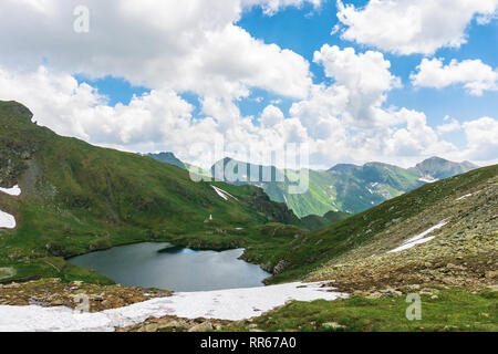 Sommer in den rumänischen Karpaten. schöne Landschaft von Fagaras Gebirge. see Capra im Tal. flauschige Wolken über dem Grat. Blick von Stockfoto