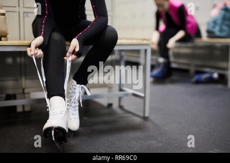 Niedrige Abschnitt Portrait von unkenntlich junge Frau binden skating Schuh im Ankleidezimmer, bevor die Praxis, kopieren Raum Stockfoto