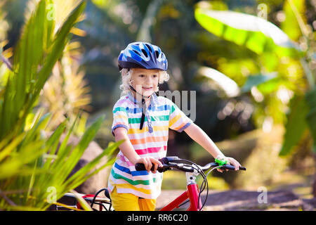 Kids on Bike im Park. Kinder in die Schule zu tragen sichere fahrradhelme. Little boy Radfahren auf sonnigen Sommertag. Aktiv gesund Outdoor Sport für y Stockfoto