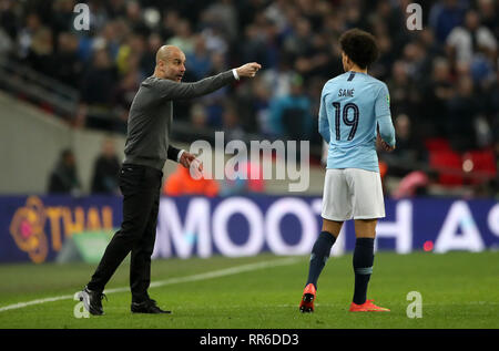 Manchester City Manager Pep Guardiola spricht mit Leroy Sane vor extra-Zeit während der carabao Cup Finale im Wembley Stadion, London. Stockfoto