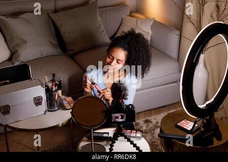 Schönheit vlogger Holding Lippenstift Make-up Tutorial während der Aufnahme Stockfoto