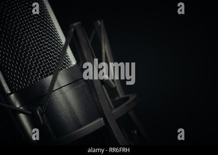 Nahaufnahme eines Studio Mikrofon auf der linken Seite des Rahmens gegen einen dunklen Hintergrund, der horizontalen Aspekt mit dem Fokus auf dem Netz aus. Stockfoto