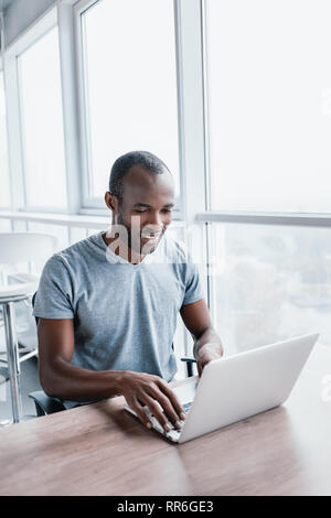 Professionelle männlichen Ökonom sucht benötigten Informationen auf tragbaren Computer, happy High Net Profit zu erhalten, verbringt wichtige Bank- betrieb. Af Stockfoto