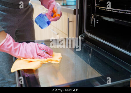 Foto von der Frau die Hände in Handschuhe Waschmaschine Backofen Stockfoto