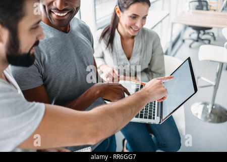 Drei junge Mitarbeiter mit Laptop und diskutieren neue Projekt im Büro, Entwicklung Strategie für On-line-Geschäft, den Austausch von Ideen, die Vorbereitung Stockfoto