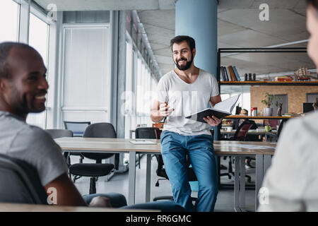 Gruppe von attraktiven multirassischen Lachen Geschäftsleute reden und Scherzen sitzen in hellen modernen Büro , multi-ethnischen Business Team Stockfoto