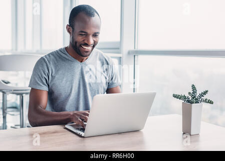 Professionelle männlichen Ökonom sucht benötigten Informationen auf tragbaren Computer, happy High Net Profit zu erhalten, verbringt wichtige Bank- betrieb. Af Stockfoto