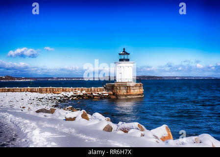 Die Portland Maine Breakwater Leuchtturm, der auch als Bug Licht, an einer kleinen Anlegestelle im Schnee an einem sonnigen blauen Himmel Winter Tag abgedeckt. Stockfoto