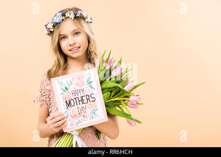 Adorable Kind mit Blumenstrauß aus rosa Tulpen und glücklichen Muttertag Grußkarte auf gelbem Hintergrund Stockfoto