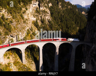 Luftaufnahme von einem roten Zug der Landwasserviadukt Kreuzung in den Schweizer Alpen Stockfoto