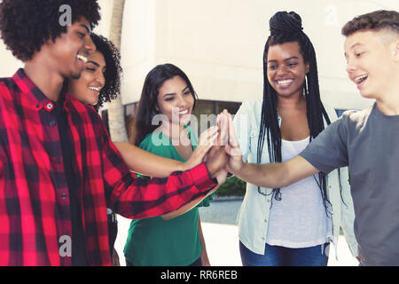 Lachen Latin und afrikanische amerikanische Männer und Frauen ein Team in der Stadt Stockfoto