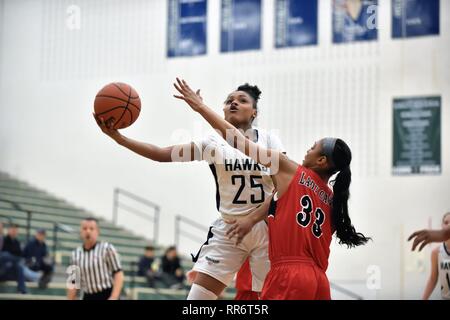 Während der Fahrt auf den Korb und die Begegnung mit einem Verteidiger, Spieler veröffentlicht einen hinterhältigen Schuss in ein Versuch zu zählen. USA. Stockfoto