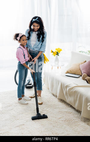 Adorable african american Kind helfen Mutter saugen Teppich Stockfoto