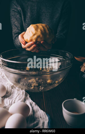 Weibliche Hände halten frisch gekneteten Teig, close-up. Frau kochen Hausgemachte Kekse Kuchen. Stockfoto