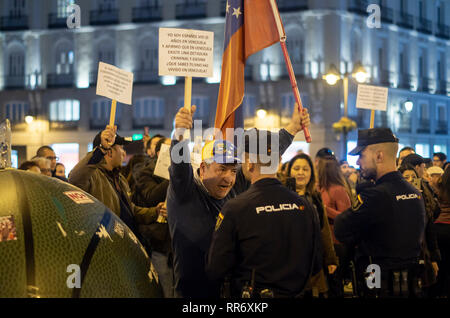 Madrid, Spanien. 24 Feb, 2019. Auseinandersetzungen zwischen den Anhängern des Maduro und der Opposition fand in Madrid statt. Der Ursprung des Streits war eine Demonstration, die von den Verfechtern der Maduro an der Puerta del Sol organisiert gegen die Intervention von Spanien in Venezuela zu protestieren. Bürger Venezuelas von der Opposition bis gezeigt und der Intervention der Polizei war notwendig Keine stärkere Auseinandersetzungen zwischen beiden Teilen zu vermeiden. Im Bild, einer der Demonstranten gegen Maduro Gesichter einen Polizisten. Er hält ein Plakat, das sagt: "Ich bin ein spanischer Staatsbürger, der in Venezuela für 25 Jahre gelebt hat und Stockfoto