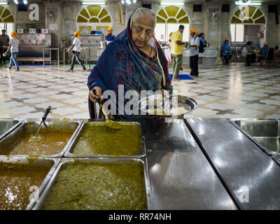 Bangkok, Bangkok, Thailand. 25 Feb, 2019. Eine indische Frau bekommt ihre Mahlzeit während der Morgen'' Langar'' (gemeinsames Essen) am Gurdwara Siri Guru Singh Sabha. Die gurdwara dient über 500 kostenlose Mahlzeiten von Montag bis Samstag und über 1.000 kostenlose Mahlzeiten an Sonntagen. Obwohl die Sikhs nicht Vegetarier sind, die langar Mahlzeiten sind Vegetarier und jeder kann sie ohne Verstoß gegen ein religiöses Edikt auf Diät. Die Mahlzeiten sind für alle, die Spaziergänge in den Gurdwara, unabhängig von ihrer Religion oder Nationalität. Die gurdwara Siri Guru Singh Sabha in Bangkok ist eine der größten Sikh Sikh (Tempel), Stockfoto