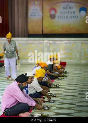 Bangkok, Bangkok, Thailand. 25 Feb, 2019. Männer sitzen auf dem Boden und in Ruhe essen während der Morgen'' Langar'' (gemeinsames Essen) am Gurdwara Siri Guru Singh Sabha. Die gurdwara dient über 500 kostenlose Mahlzeiten von Montag bis Samstag und über 1.000 kostenlose Mahlzeiten an Sonntagen. Die Mahlzeiten sind für alle, die Spaziergänge in den Gurdwara, unabhängig von ihrer Religion oder Nationalität. Obwohl die Sikhs nicht Vegetarier sind, die langar Mahlzeiten sind Vegetarier und jeder kann sie ohne Verstoß gegen ein religiöses Edikt auf Diät. Die gurdwara Siri Guru Singh Sabha in Bangkok ist eine der größten Sikh Sikh (Te Stockfoto