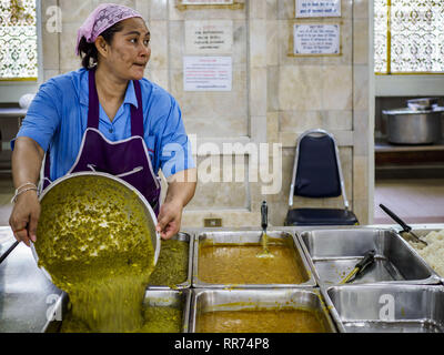 Bangkok, Bangkok, Thailand. 25 Feb, 2019. Eine Küche Mitarbeiter bringt zum Buffet line Curry während der Morgen'' Langar'' (gemeinsames Essen) am Gurdwara Siri Guru Singh Sabha. Die gurdwara dient über 500 kostenlose Mahlzeiten von Montag bis Samstag und über 1.000 kostenlose Mahlzeiten an Sonntagen. Die Mahlzeiten sind für alle, die Spaziergänge in den Gurdwara, unabhängig von ihrer Religion oder Nationalität. Die gurdwara Siri Guru Singh Sabha in Bangkok ist eine der größten Sikh Sikh (Tempel) außerhalb von Indien. Es ist in Bangkok' 'Little India'' Nachbarschaft, in der Nähe von Chinatown. Mit dem Bau der Gurdwara Stockfoto