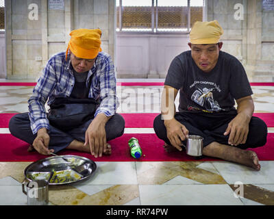 Bangkok, Bangkok, Thailand. 25 Feb, 2019. Thai Männer essen ihre Mahlzeiten während der Morgen'' Langar'' (gemeinsames Essen) am Gurdwara Siri Guru Singh Sabha. Die gurdwara dient über 500 kostenlose Mahlzeiten von Montag bis Samstag und über 1.000 kostenlose Mahlzeiten an Sonntagen. Obwohl die Sikhs nicht Vegetarier sind, die langar Mahlzeiten sind Vegetarier und jeder kann sie ohne Verstoß gegen ein religiöses Edikt auf Diät. Die Mahlzeiten sind für alle, die Spaziergänge in den Gurdwara, unabhängig von ihrer Religion oder Nationalität. Die gurdwara Siri Guru Singh Sabha in Bangkok ist eine der größten Sikh Sikh (Tempel) außerhalb Stockfoto