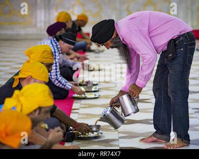 Bangkok, Bangkok, Thailand. 25 Feb, 2019. Ein freiwilliger gießt heißen Tee für Männer essen während der Morgen'' Langar'' (gemeinsames Essen) am Gurdwara Siri Guru Singh Sabha. Die gurdwara dient über 500 kostenlose Mahlzeiten von Montag bis Samstag und über 1.000 kostenlose Mahlzeiten an Sonntagen. Obwohl die Sikhs nicht Vegetarier sind, die langar Mahlzeiten sind Vegetarier und jeder kann sie ohne Verstoß gegen ein religiöses Edikt auf Diät. Die Mahlzeiten sind für alle, die Spaziergänge in den Gurdwara, unabhängig von ihrer Religion oder Nationalität. Die gurdwara Siri Guru Singh Sabha in Bangkok ist eine der größten Sikh Sikh (t Stockfoto