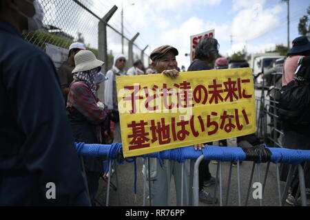 NAGO, Japan - 25. Februar: Demonstranten mit Plakaten stehen vor dem Tor, während Baufahrzeuge betritt den Ort während der Protest gegen US-Basis außerhalb der USA Basislager Schwab Tor, die am 25. Februar 2019 in Nago, Präfektur Okinawa, Japan. Auf der Grundlage der Präfektur Referendums, mehr als 70 Prozent der Wähler in Okinawa lehnen US-base in Henoko. (Foto von Richard Atrero de Guzman/LBA) Stockfoto