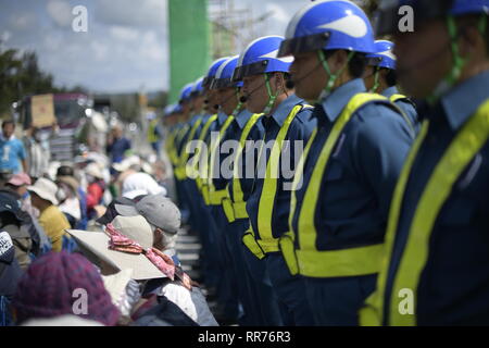 NAGO, Japan - 25. Februar: Die Wachen hinter Demonstranten während der Proteste gegen US-Basis außerhalb der USA Basislager Schwab Tor, die am 25. Februar 2019 in Nago, Präfektur Okinawa, Japan. Auf der Grundlage der Präfektur Referendums, mehr als 70 Prozent der Wähler in Okinawa lehnen US-base in Henoko. (Foto von Richard Atrero de Guzman/LBA) Stockfoto