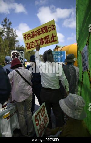 NAGO, Japan - 25. Februar: Demonstranten mit Plakaten stehen vor dem Tor, während Baufahrzeuge betritt den Ort während der Protest gegen US-Basis außerhalb der USA Basislager Schwab Tor, die am 25. Februar 2019 in Nago, Präfektur Okinawa, Japan. Auf der Grundlage der Präfektur Referendums, mehr als 70 Prozent der Wähler in Okinawa lehnen US-base in Henoko. (Foto von Richard Atrero de Guzman/LBA) Stockfoto