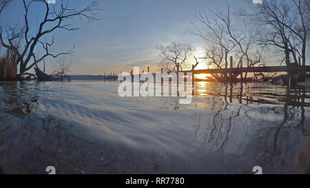 Berlin, Deutschland. 25 Feb, 2019. Die Sonne über dem Wannsee und hinter einer Fußgängerbrücke. Credit: Paul Zinken/dpa/Alamy leben Nachrichten Stockfoto