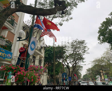 Hanoi, Vietnam. 25 Feb, 2019. Ein Arbeitnehmer hängt Fahnen der USA, Nordkorea und den host Vietnam vor dem Gipfeltreffen von US-Präsident Trump und der nordkoreanischen Herrscher Kim. Die zweite Sitzung zwischen Trumpf und Kim ist für den 27.-28. Februar in Hanoi geplant. Credit: Can Merey/dpa/Alamy leben Nachrichten Stockfoto