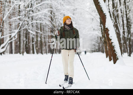 Fröhliche Frau Skifahren im Wald Stockfoto